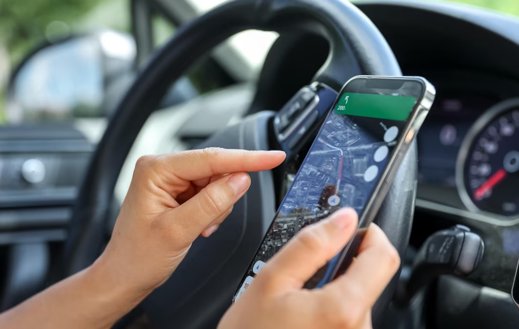 hands holding phone with a map on it in the car