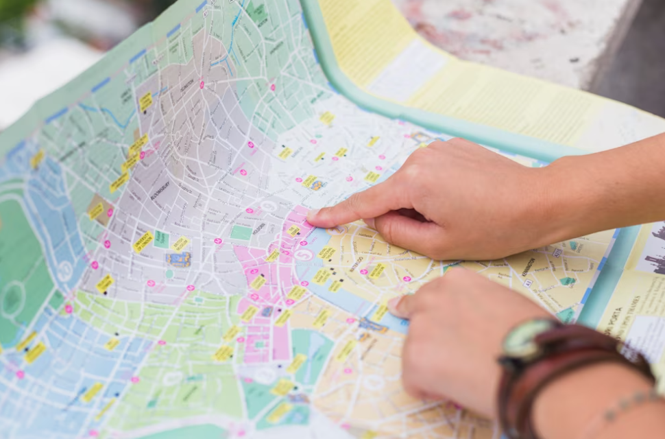 hands of two persons pointing on the colorful map