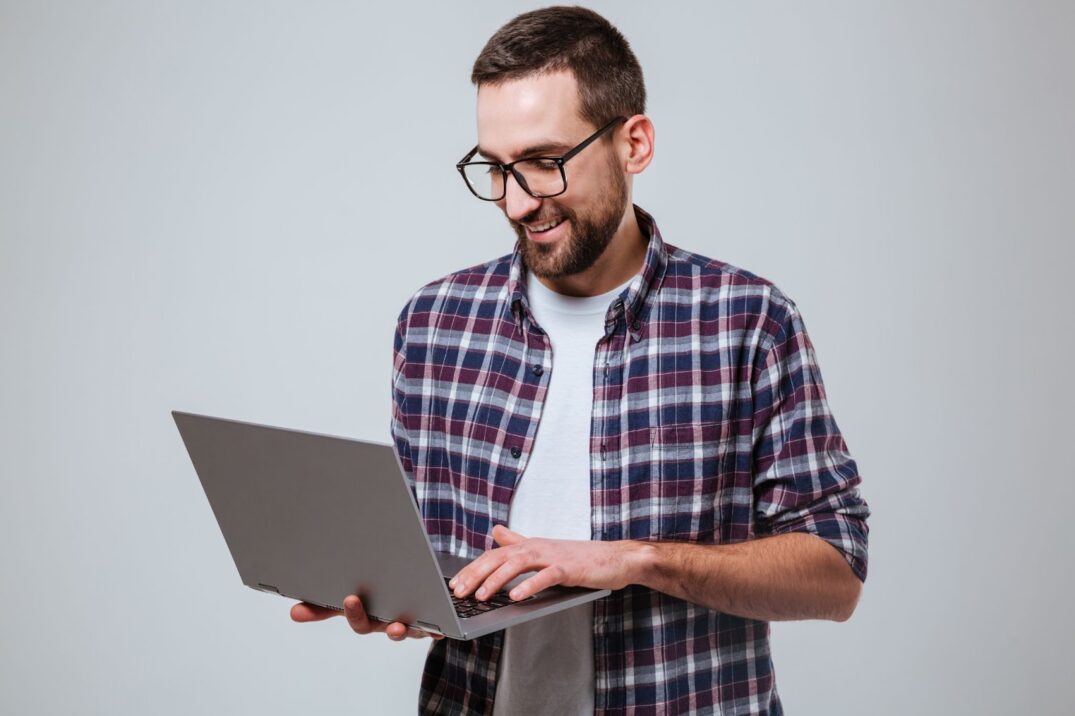 A man standing with a laptop