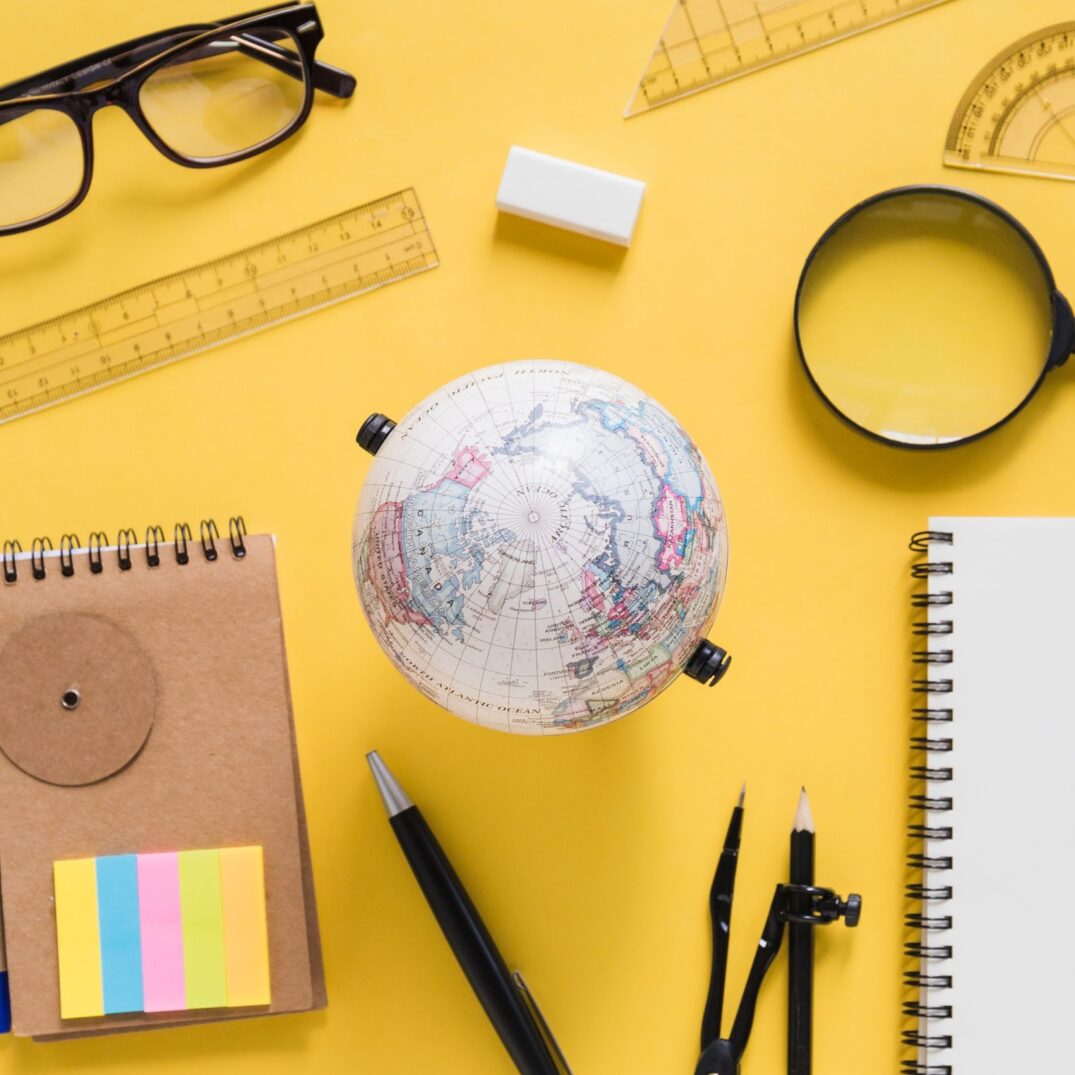 View of globe with various equipments on yellow background